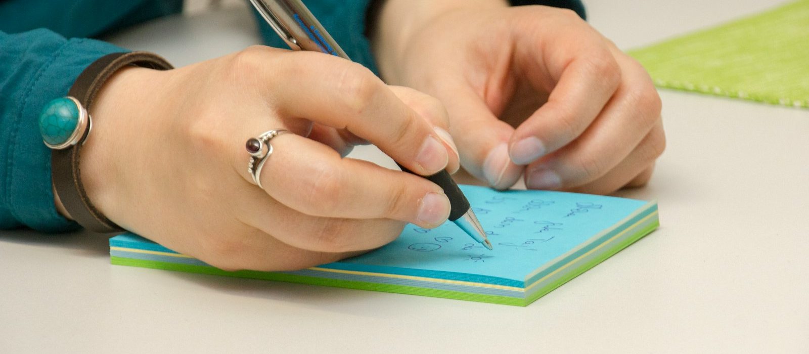 Photo by Julia Taubitz a person writing on a notepad with a pen